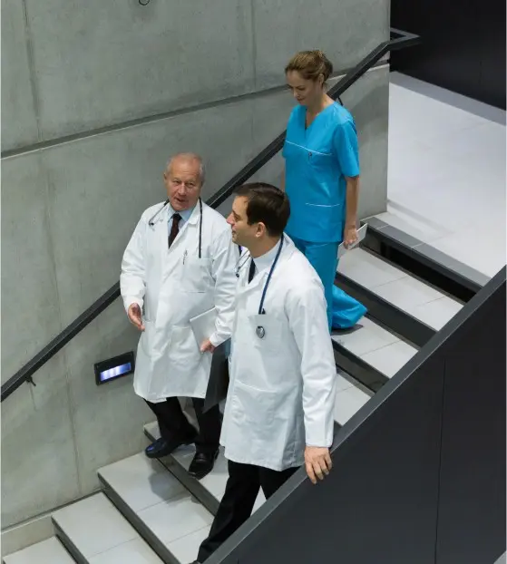 Medical professionals walking up a stairway in a hospital