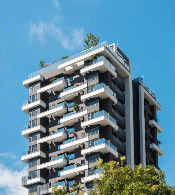 Modern high-rise building with many balconies and greenery