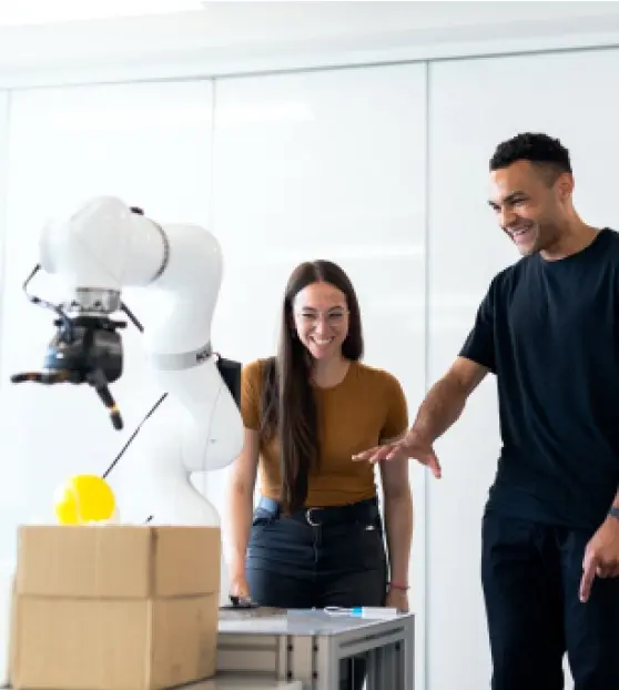 Two people interact with a robotic arm for AI and IoT Solutions