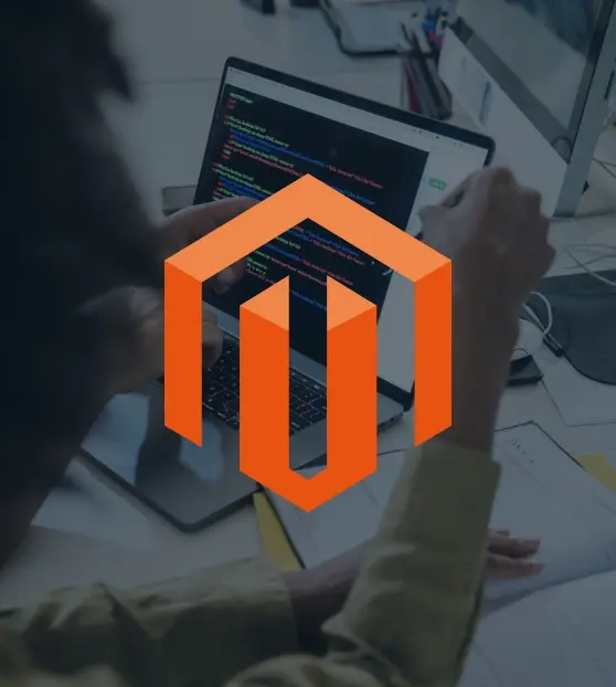 Developer coding with Magento logo on laptop screen