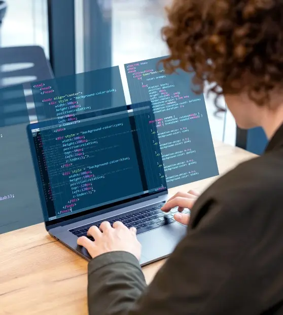 Person coding on a laptop with floating screens