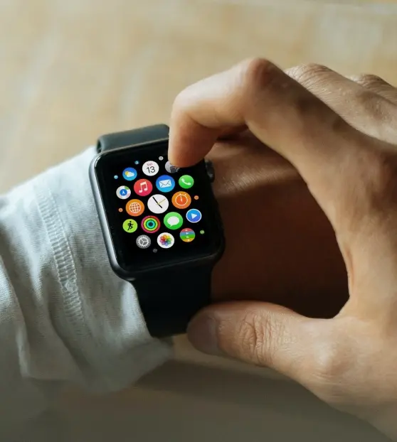 A hand using a smartwatch with colorful app icons