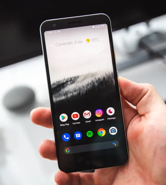 Hand holding smartphone with app icons visible