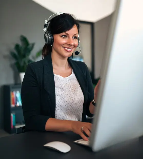 Woman smiling while wearing a headset at a desk